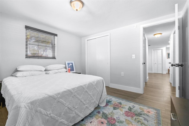 bedroom featuring a closet, baseboards, and wood finished floors