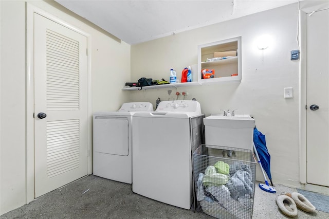 laundry area featuring laundry area, separate washer and dryer, and a sink