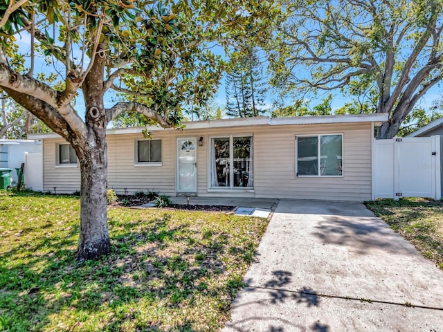 ranch-style house featuring a front lawn and fence