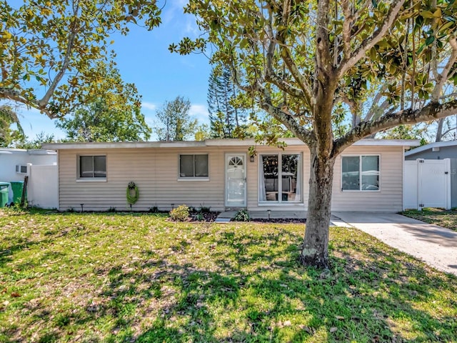 single story home with driveway, a front yard, and fence