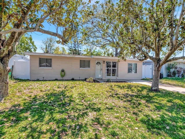 ranch-style house featuring a front yard and fence