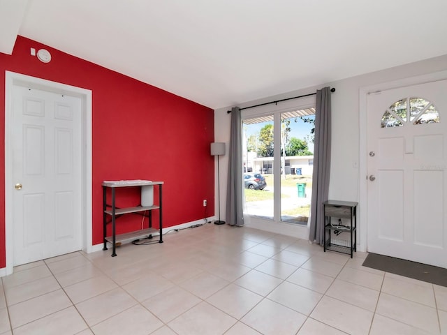 foyer featuring baseboards and light tile patterned flooring