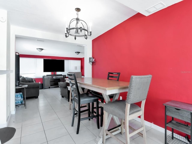 tiled dining space featuring visible vents, baseboards, and a notable chandelier