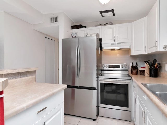 kitchen with visible vents, under cabinet range hood, light countertops, stainless steel appliances, and white cabinetry