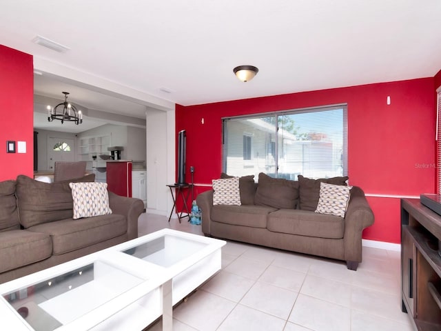 living room with visible vents, an accent wall, baseboards, a chandelier, and light tile patterned floors