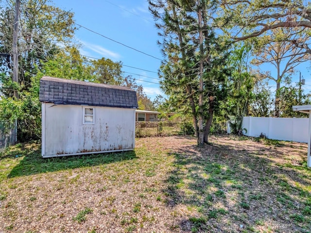 view of yard with an outbuilding, a fenced backyard, and a shed