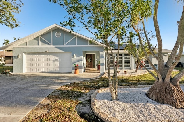 view of front of home with solar panels, an attached garage, driveway, and stucco siding