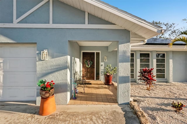 entrance to property with stucco siding and solar panels