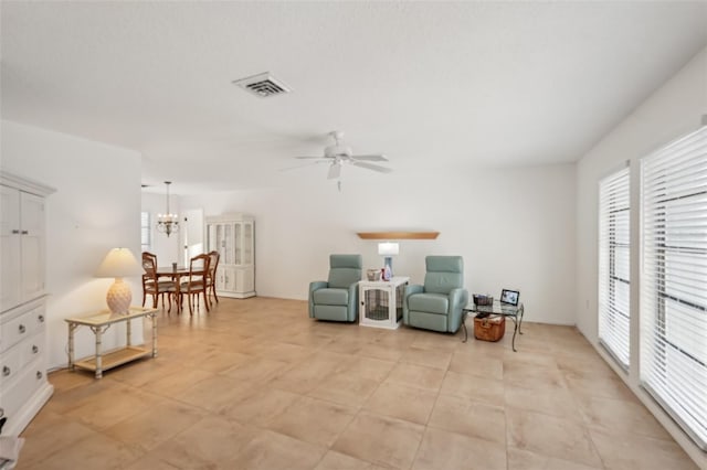 sitting room featuring ceiling fan with notable chandelier and visible vents