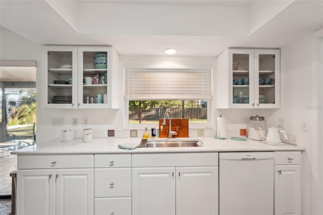 kitchen with a sink, white cabinets, glass insert cabinets, and white dishwasher