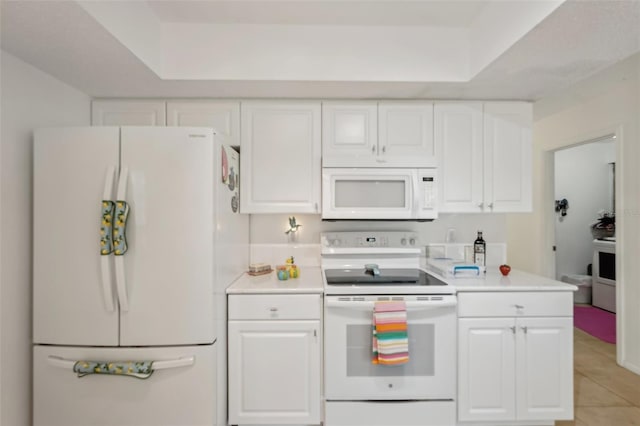 kitchen featuring white appliances, white cabinets, and light countertops