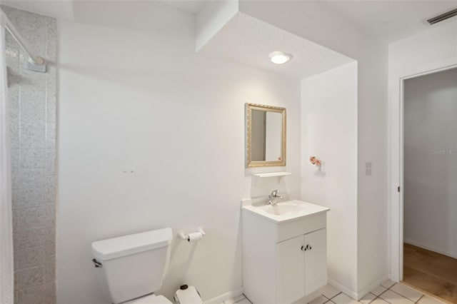 bathroom featuring vanity, visible vents, tiled shower, tile patterned flooring, and toilet