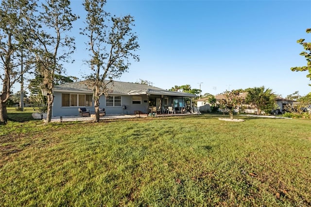 rear view of house with a lawn and a patio area