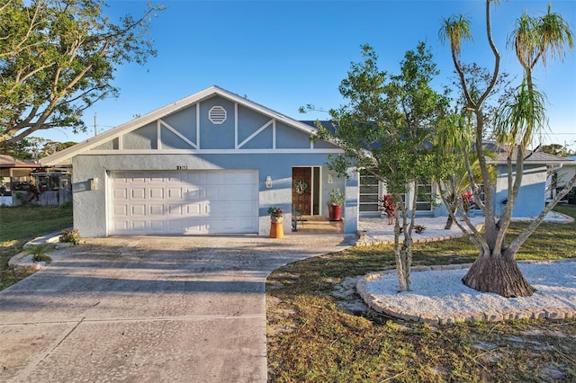 view of front facade with stucco siding, driveway, and a garage