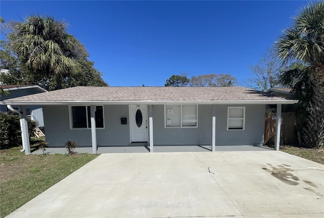 ranch-style house with covered porch, stucco siding, and roof with shingles