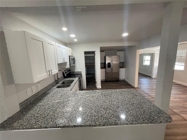 645 38th Ave S, Saint Petersburg, FL 33705 - kitchen with a sink, appliances with stainless steel finishes, dark wood-style floors, and dark stone countertops