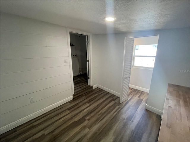 645 38th Ave S, Saint Petersburg, FL 33705 - spare room with baseboards, a textured ceiling, and dark wood finished floors