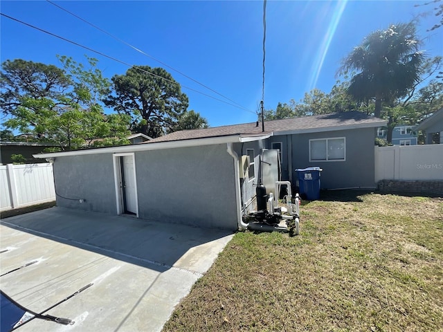 645 38th Ave S, Saint Petersburg, FL 33705 - back of property with a patio area, stucco siding, a lawn, and fence