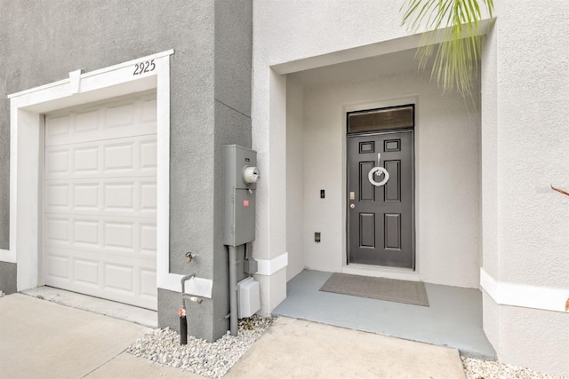 entrance to property featuring stucco siding and a garage