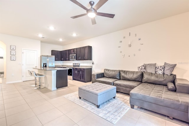 living area featuring light tile patterned floors, baseboards, ceiling fan, and recessed lighting