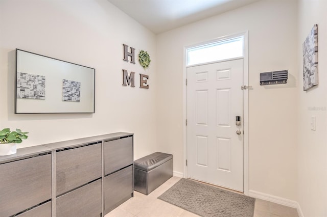 entrance foyer with light tile patterned floors and baseboards