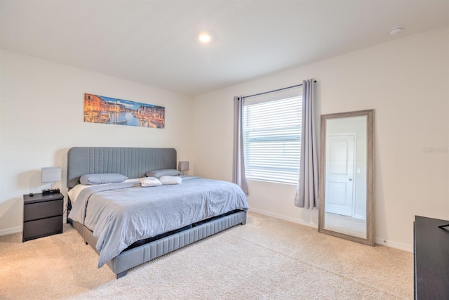 bedroom featuring baseboards and light carpet