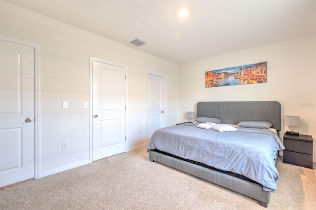 carpeted bedroom featuring visible vents and baseboards