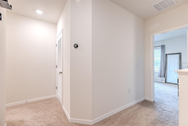 corridor with visible vents, carpet floors, and baseboards