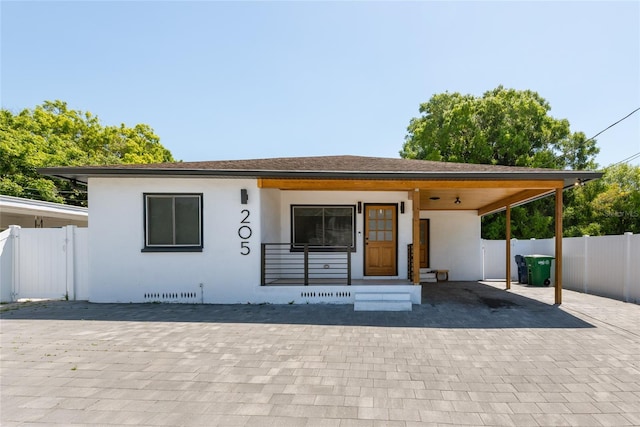 view of front of home featuring stucco siding and fence