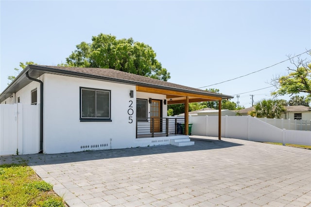 view of front facade featuring crawl space, stucco siding, and fence