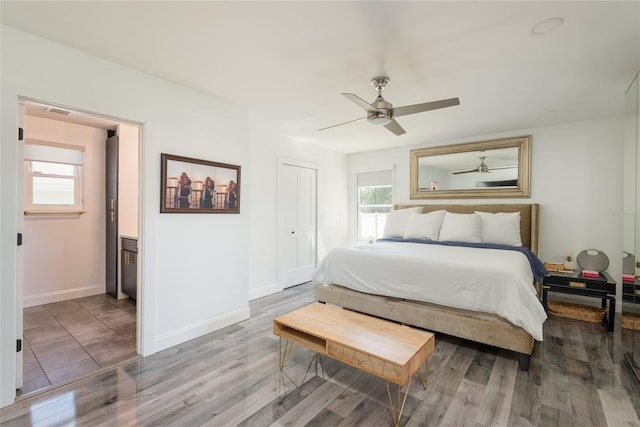 bedroom featuring ceiling fan, baseboards, and wood finished floors