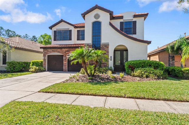 mediterranean / spanish-style house featuring stucco siding, french doors, a garage, stone siding, and driveway