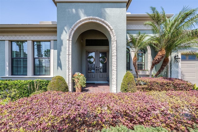 property entrance with stucco siding and french doors