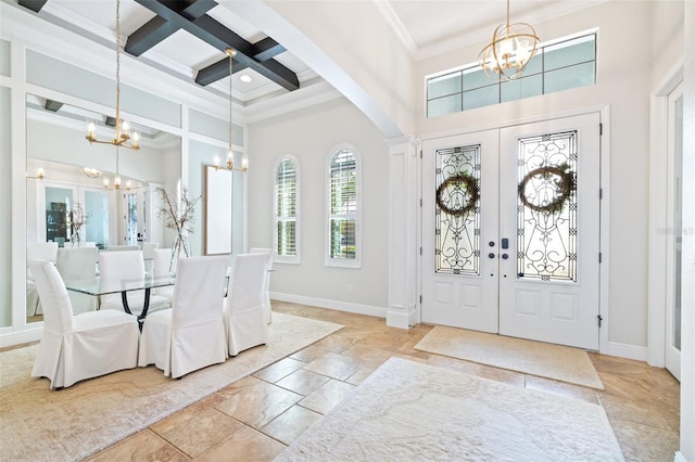 entrance foyer featuring beamed ceiling, coffered ceiling, french doors, an inviting chandelier, and a towering ceiling