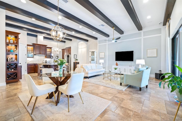 dining space with beam ceiling, ceiling fan with notable chandelier, stone finish floor, and baseboards