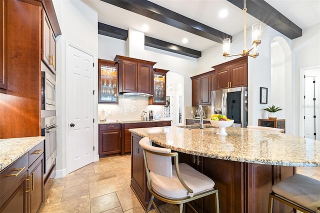 kitchen with backsplash, a breakfast bar, beam ceiling, stainless steel appliances, and a sink