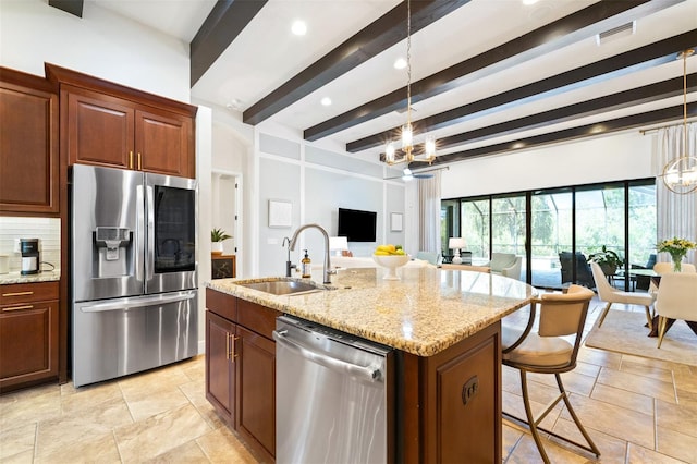 kitchen with a sink, backsplash, a notable chandelier, and appliances with stainless steel finishes