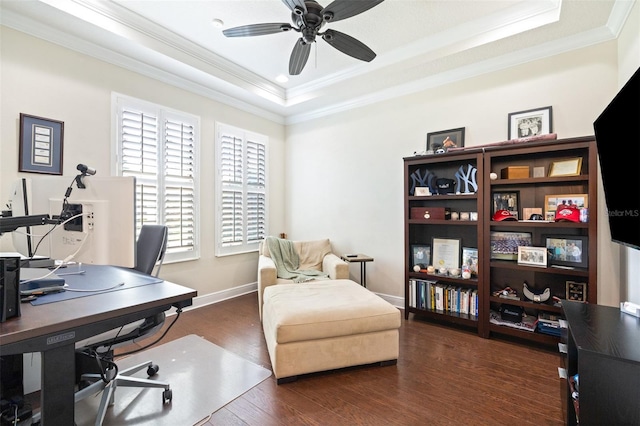 office area featuring wood finished floors, baseboards, ceiling fan, ornamental molding, and a raised ceiling