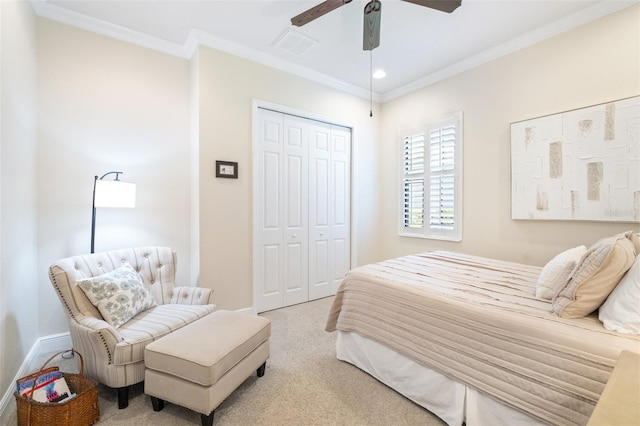 bedroom with baseboards, visible vents, carpet floors, ornamental molding, and a closet