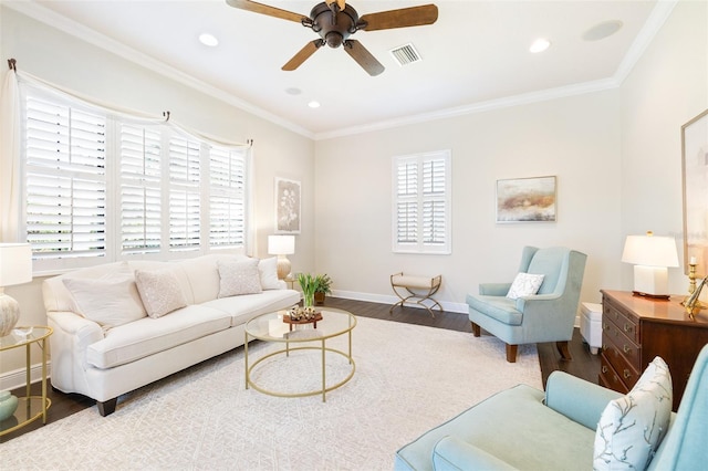 living area featuring crown molding, wood finished floors, visible vents, and baseboards