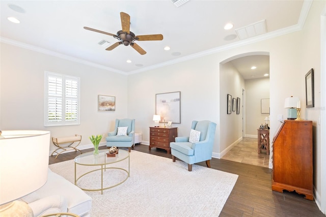 living room featuring visible vents, crown molding, baseboards, arched walkways, and dark wood-style flooring