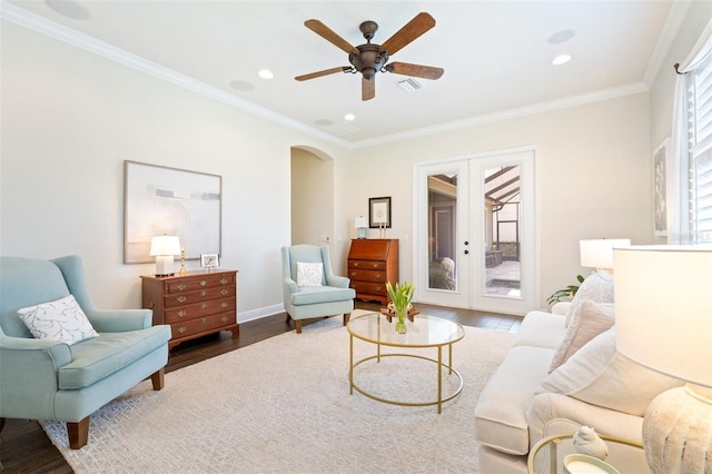 interior space featuring wood finished floors, french doors, arched walkways, crown molding, and baseboards