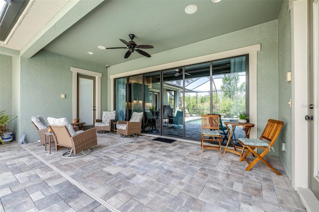 view of patio / terrace featuring glass enclosure and a ceiling fan