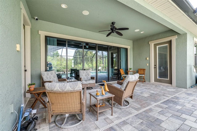 view of patio / terrace featuring glass enclosure and a ceiling fan