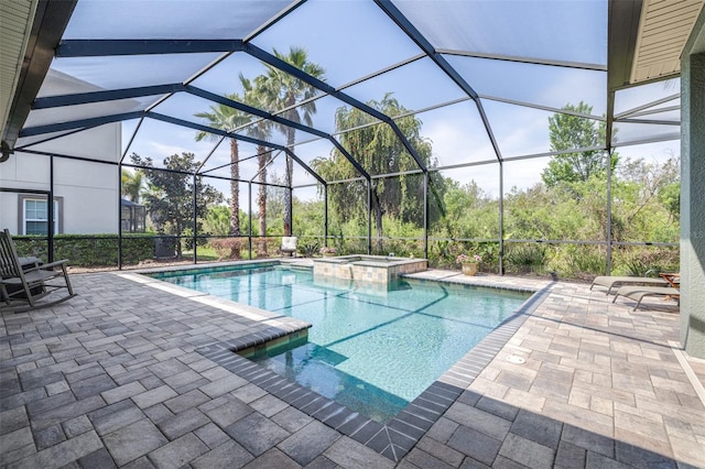 view of pool featuring a pool with connected hot tub, a lanai, and a patio area