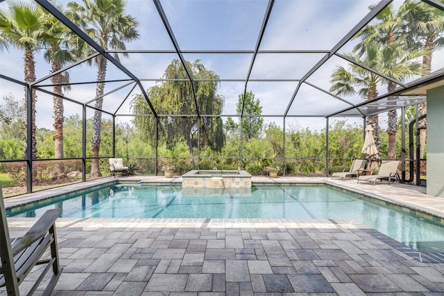 view of pool featuring glass enclosure, a pool with connected hot tub, and a patio