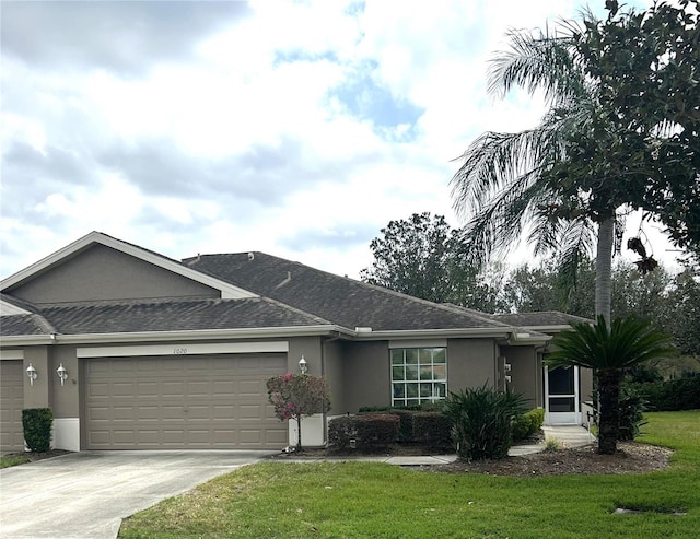 ranch-style home with stucco siding, a garage, concrete driveway, and a front yard