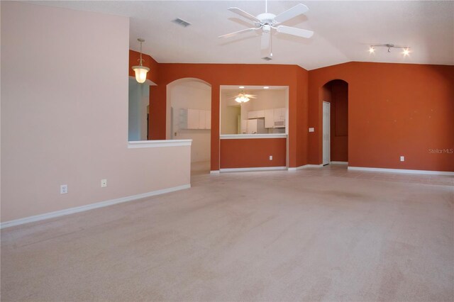 1020 New Winsor Loop Unit 46, Sun City Center, FL 33573 - unfurnished living room featuring arched walkways, ceiling fan, vaulted ceiling, light carpet, and baseboards