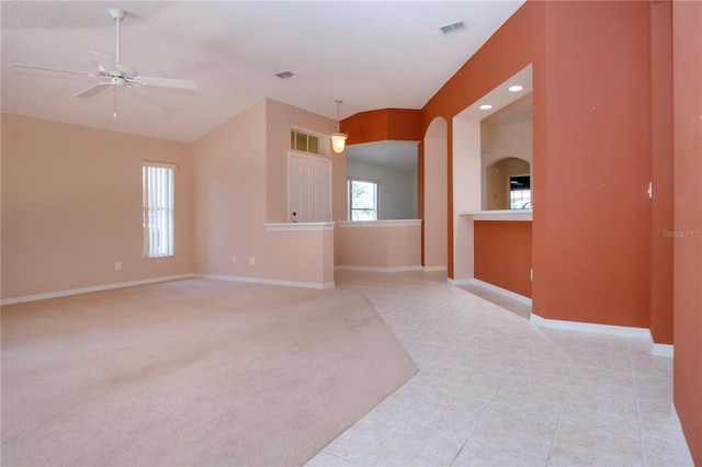 1020 New Winsor Loop Unit 46, Sun City Center, FL 33573 - empty room featuring ceiling fan, baseboards, arched walkways, light tile patterned floors, and vaulted ceiling