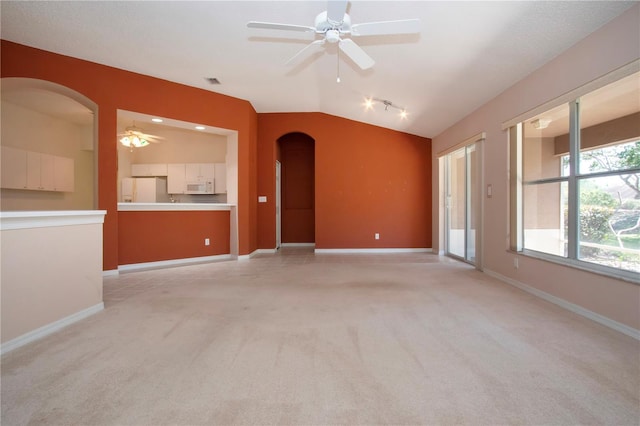 1020 New Winsor Loop Unit 46, Sun City Center, FL 33573 - spare room with arched walkways, a ceiling fan, lofted ceiling, light colored carpet, and baseboards